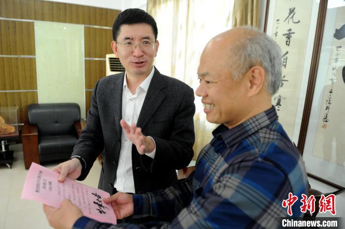 中国移动福建公司漳州分公司总经理沈火平(左)向台商介绍移动大礼包活动内容。 张金川 摄