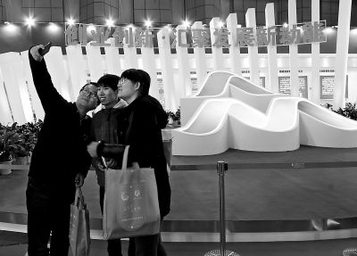 昨天,参观者用手机自拍功能跟双创标识合影。