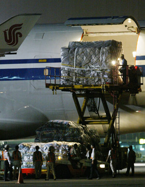Workers unload relief materials from China's mainland after the special flight arrived at Kaohsiung, southeast China's Taiwan Province, Aug. 18, 2009.