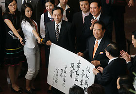 James Soong (holding the inscription, centre), chairman of People First Party in Taiwan, shows his inscription describing his feelings upon finishing a visit to the Shanghai Urban Planning Exhibition Centre shortly after his arrival in the East China metropolis yesterday afternoon. Soong was in Shanghai to attend the Cross-Straits Non-governmental Forum of Elites, which opens today.												 Gao Erqiang