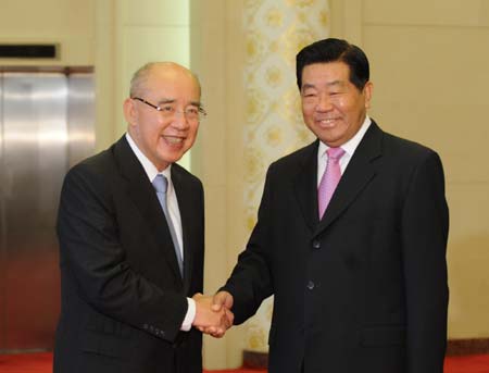 Jia Qinglin (R), chairman of the National Committee of the Chinese People's Political Consultative Conference, who is also a member of the Standing Committee of the Political Bureau of the Communist Party of China Central Committee, shakes hands with Kuomintang (KMT) Chairman Wu Poh-hsiung during their meeting at the Great Hall of the People in Beijing, capital of China, May 25, 2009.