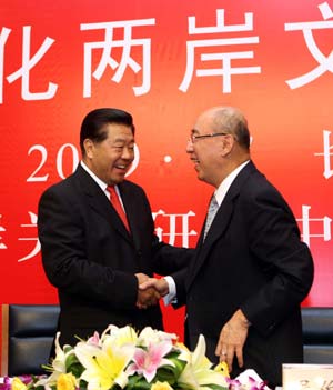 Jia Qinglin (L), chairman of the National Committee of the Chinese People's Political Consultative Conference, shakes hands with Kuomintang (KMT)'s chairman Wu Poh-hsiung at the closing ceremony of the fifth Cross-Straits Economic, Trade and Culture Forum in Changsha, capital of central China's Hunan Province, July 12, 2009. (Xinhua/Xing Guangli)