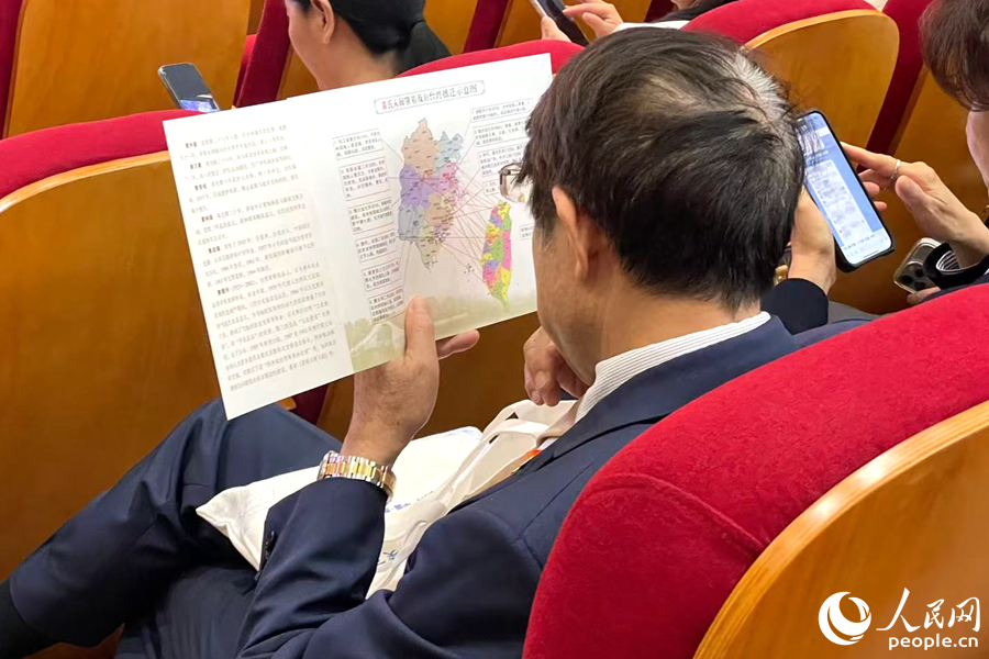 一位嘉宾认真端详姓氏入闽及迁台示意图。人民网记者 林盈摄