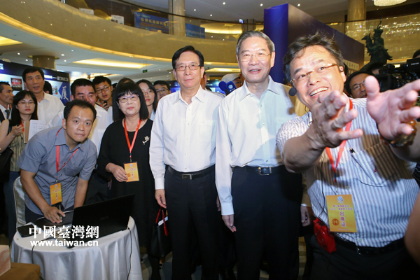 在“动漫展区”,来自台湾的陈天赏向张志军介绍利用红色龙虾壳制作的“虾兵虾将”。