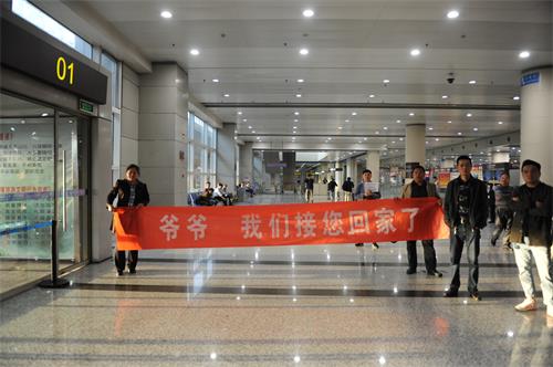 杨家人手拿横幅迎接爷爷回家。 杨家人手拿横幅迎接爷爷回家。