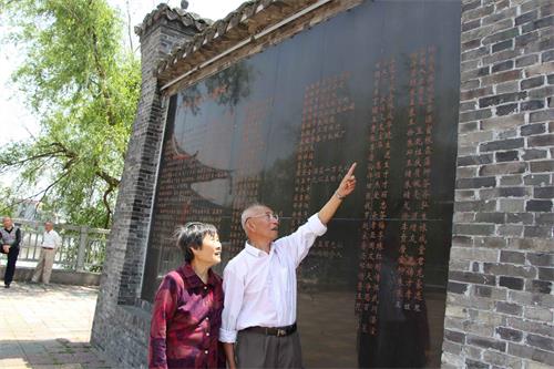 楊信璉向記者介紹刻有父親名字的華光大橋功德碑。