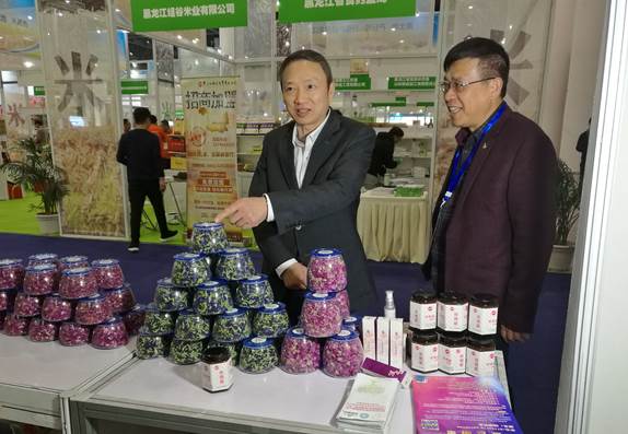 省委台办主任周敏谦(左)在四川双龙农牧开发有限公司展台与台商林云飞(右)亲切交流