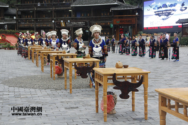 西江千户苗寨门口苗族姑娘和祖祖盛装打扮,迎接宾客,桌上是苗族人自酿的米酒 西江千户苗寨门口苗族姑娘和祖祖盛装打扮,迎接宾客,桌上是苗族人自酿的米酒