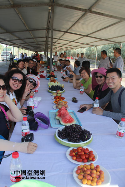 高雄市基层农会参访团一行在农五师85团葡萄园边品尝香甜的水果边进行座谈交流