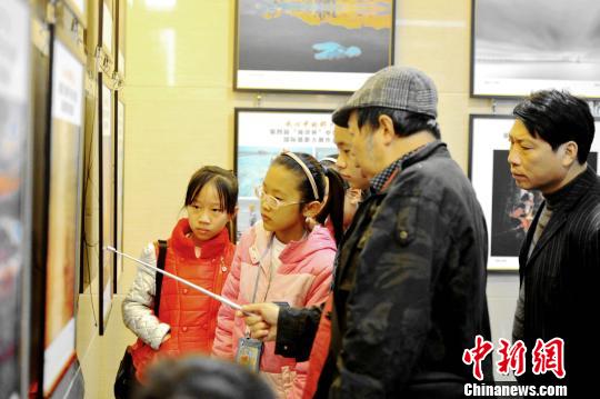 图为获奖作品展览,摄影师教授小朋友摄影技巧。 图为获奖作品展览,摄影师教授小朋友摄影技巧。