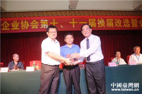 海南省台办副主任王克禧(中)主持海南台协新老会长江裕昌(右)、黄益丰的交接仪式