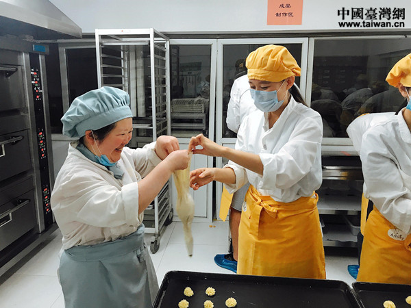 “喜憨儿”慧慧在帮助实习生魏曼芯调整工具,齐心协作,挤出的曲奇饼干形状标准,精致均匀 “喜憨儿”慧慧在帮助实习生魏曼芯调整工具,齐心协作,挤出的曲奇饼干形状标准,精致均匀