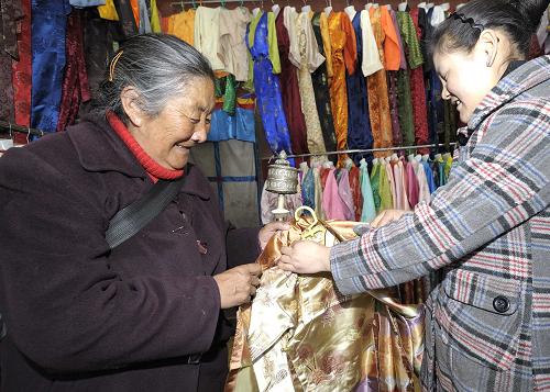 2月18日,一名藏族老阿妈在选购藏装。藏历新年来临之际,藏装作为藏族传统节日必穿的服饰受到广大藏族群众的青睐。新华社记者 普布扎西 摄