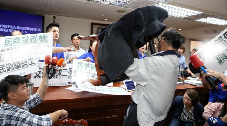 民进党“立委”吴焜裕在混乱中搬椅子抵抗,导致“蓝委”受伤。(图片来源:台湾联合新闻网) 民进党“立委”吴焜裕在混乱中搬椅子抵抗,导致“蓝委”受伤。(图片来源:台湾联合新闻网)