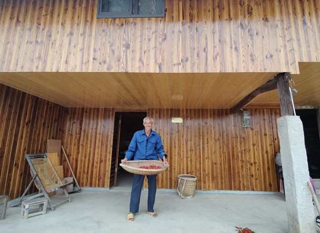 老党员正在自家屋前筛小辣椒。徐俊聪摄