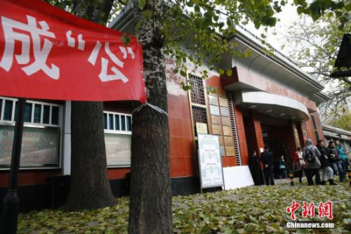 资料图:2014年11月30日,2015年度中央机关及其直属机构公务员录用考试公共科目笔试拉开“战幕”,结束上午考试的考生走出北京市一处门口铺满落叶的考场。 中新社发 刘关关 摄