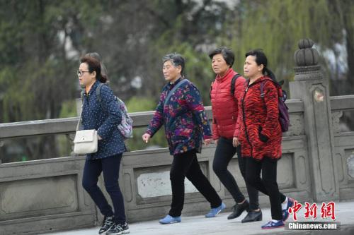 3月14日,四川成都街头行人身着厚衣物出行。受北方冷空气影响,四川盆地连日来气温持续走低,局部还出现了降雪天气,民众纷纷添加厚衣物御寒。 中新社记者 张浪 摄
