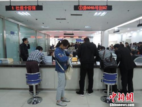 尽管服务窗口前有便民座椅,但是大多数市民仍愿意把便民座椅搁置一旁,弯着腰趴在服务窗台上与工作人员交流。 韩章云 摄