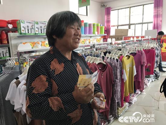 黄兰各拿着爱心卡将在超市兑换大米。(记者 王莉莉 摄)