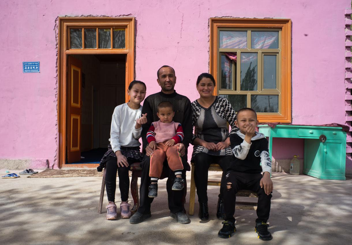 村民孜来汗·米吉提一家在新房前合影留念。