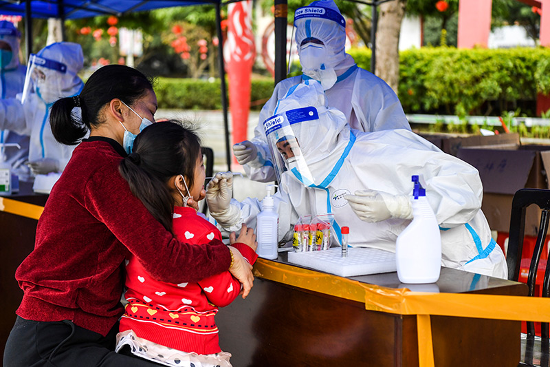 2022年2月16日,在广西百色市德保县,医务人员在做核酸采样。