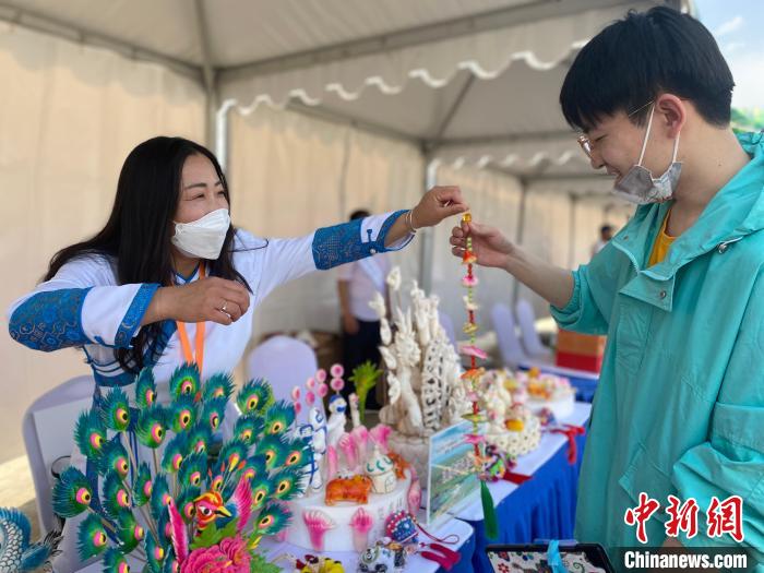 图为贺春梅将自己捏的寒燕送给民众。 张玮 摄