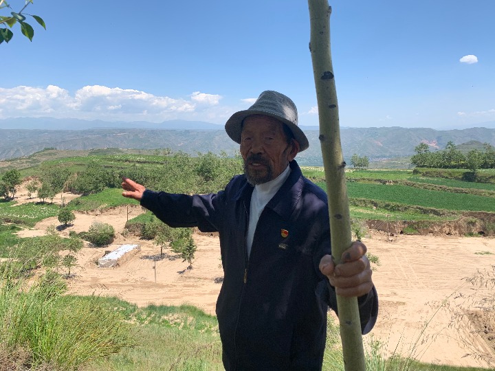 李洪占给记者展示他曾种过的树。新华社记者李琳海摄