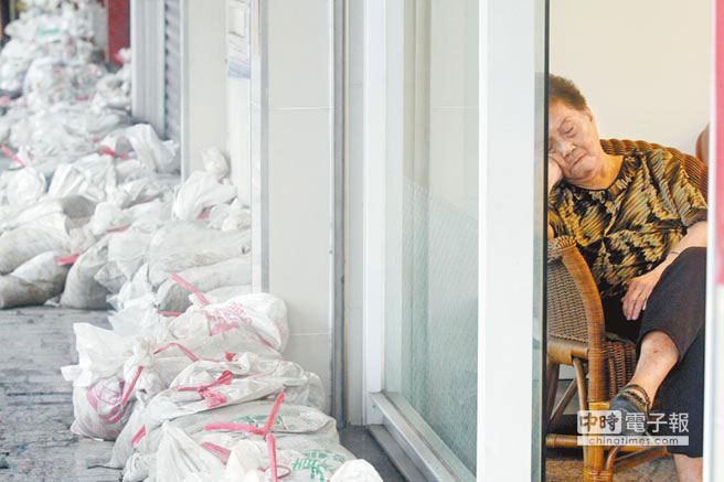 高雄凯旋路上连日大雨导致民宅积水,家家户户堆起沙包,阿嬷担心地倚在门边,不知何日天晴 高雄凯旋路上连日大雨导致民宅积水,家家户户堆起沙包,阿嬷担心地倚在门边,不知何日天晴