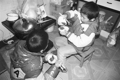 小秋鹏和小鸿昆兄弟俩正在就着辣椒水吃晚饭