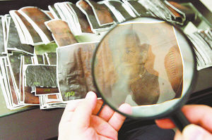 图片说明:刘先生将保险柜内的现金灰烬一张张分开,并粘贴到白纸上