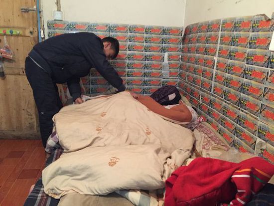 在熊先生提供的小屋里,王亮正在为妹妹盖被子。