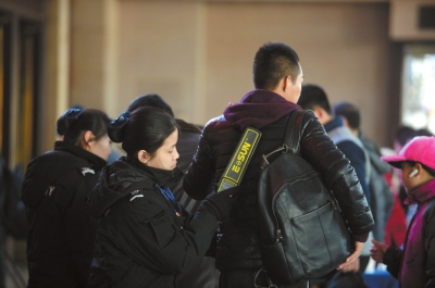 安检员对旅客进行手检。