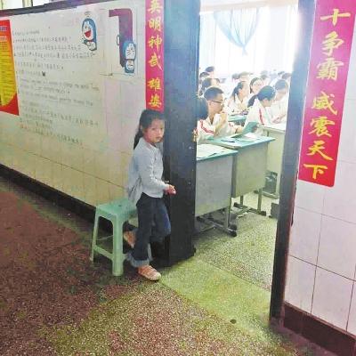 教室外,小女孩雙眼露出害怕神情。