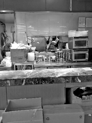 餐厅员工用筷子从外卖盆中夹菜吃。