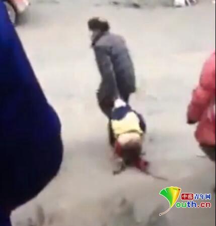 爷爷当街拖拽孙子。视频截图