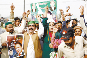 25日,谢里夫的支持者高举他的海报,在拉合尔机场外等待他的归来