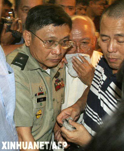 11月29日,菲律宾受审军人头目(左)与支持者被军警带出位于马尼拉马卡蒂金融区的半岛酒店。一度占据酒店的受审军人在政府压力下被迫投降,受审军人与政府对峙事件已经结束。 新华社/法新