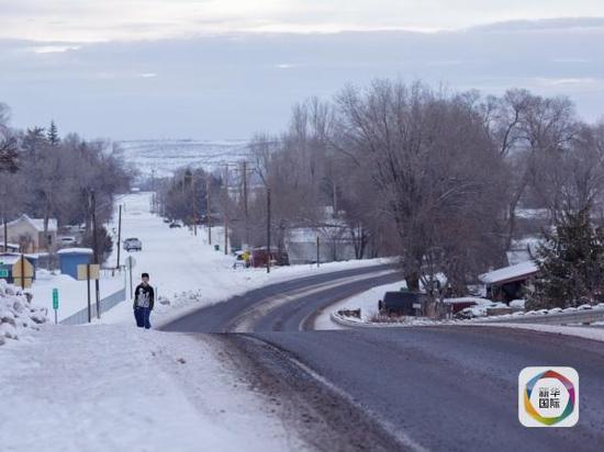 美国俄勒冈州,一名男孩走在马卢尔国家野生动物保护区外的公路上。(新华社/法新)