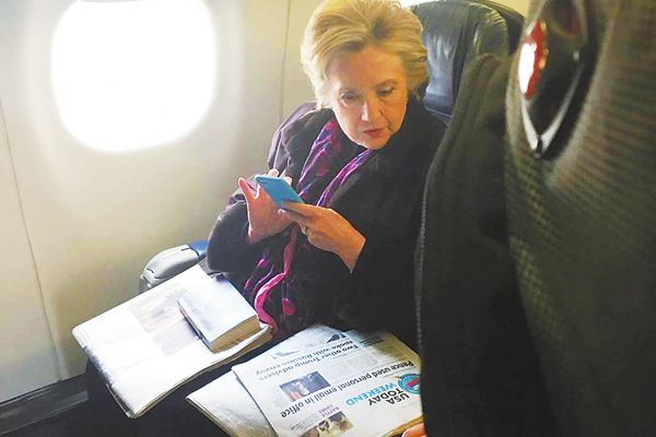3日,希拉里在飞机上看副总统彭斯“邮件门”事件的报道。