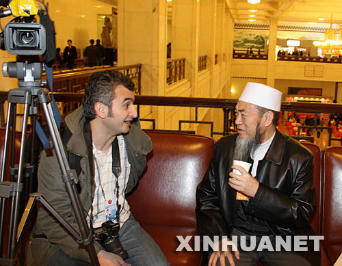 3月5日,第十一届全国人民代表大会第一次会议在北京人民大会堂开幕。这是列席开幕会的全国政协委员马开贤(回族)接受土耳其世界新闻通讯社记者欧斯曼采访。 新华社记者张燕辉 摄