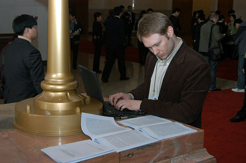 3月5日上午9时,第十一届全国人民代表大会第一次会议在人民大会堂开幕。图为外国记者查阅大会资料。新华网 郭毅 摄