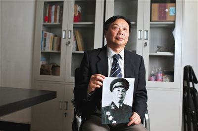 陈人康抱着父亲陈士榘的照片。1937年,时任八路军115师343旅参谋长的陈士榘参与平型关战役。新京报记者
