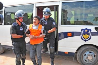 2013年6月,梁开武被押下警车指认现场。