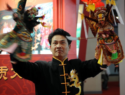 11月27日,福建漳州木偶剧团的演员在文博会上表演布袋木偶戏。 当日,为期4天的首届海峡两岸(厦门)文化产业博览交易会在厦门文化艺术中心开幕,海峡两岸各种文化产业在展会上集中亮相。据介绍,在主展馆960个展位中,来自台湾地区的标准展位有321个,占33.43%,展出了包括传统工艺美术、茶文化、食文化、现代数码娱乐产品、动漫等在内的台湾文化产业。 新华社记者 姜克红 摄