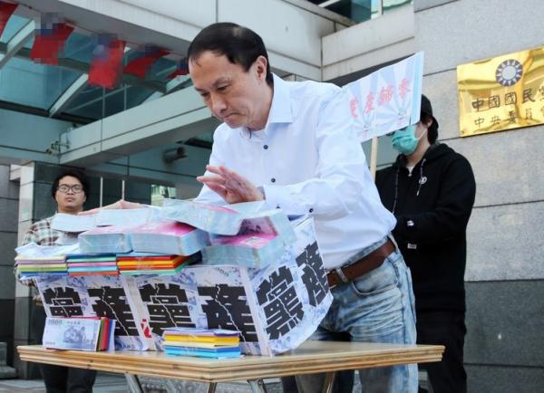 国民党主席候选人李新提议“党产归零,党员分配”,在记者会上推倒象征党产的墙