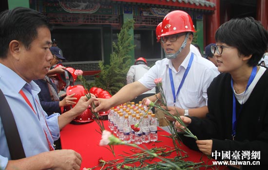工作人员向嘉宾发放祭拜鲜花。 工作人员向嘉宾发放祭拜鲜花。