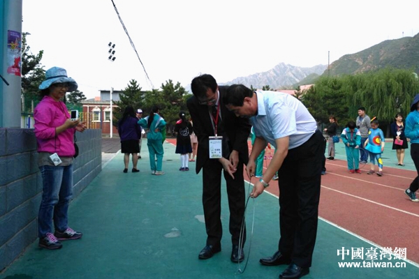 军响中心小学校长(右)与中山小学校长(左)交流滚铁环游戏 军响中心小学校长(右)与中山小学校长(左)交流滚铁环游戏