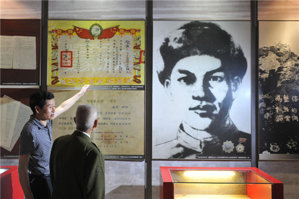 上图:邱少云弟弟邱少华(右)和邱少云侄儿邱光兵(左)经常到重庆邱少云烈士事迹陈列馆参观,墙上是邱少云画像和中朝两国向邱少云颁发的英雄证书放大版(5月18日摄) 上图:邱少云弟弟邱少华(右)和邱少云侄儿邱光兵(左)经常到重庆邱少云烈士事迹陈列馆参观,墙上是邱少云画像和中朝两国向邱少云颁发的英雄证书放大版(5月18日摄)