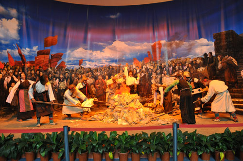 图为《西藏民主改革50年大型展览》第二展区展出的“焚烧契书”实景。民主改革使西藏百万农奴彻底摆脱了“三大领主”残酷的剥削和压迫,获得解放的农奴们围绕着篝火,焚烧卖身契、地契、债约,欢庆获得自由和土地。