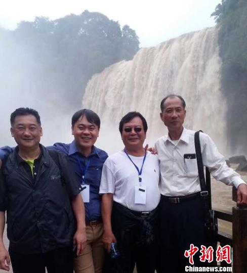 台商们在黄果树瀑布前合影。　刘鹏 摄